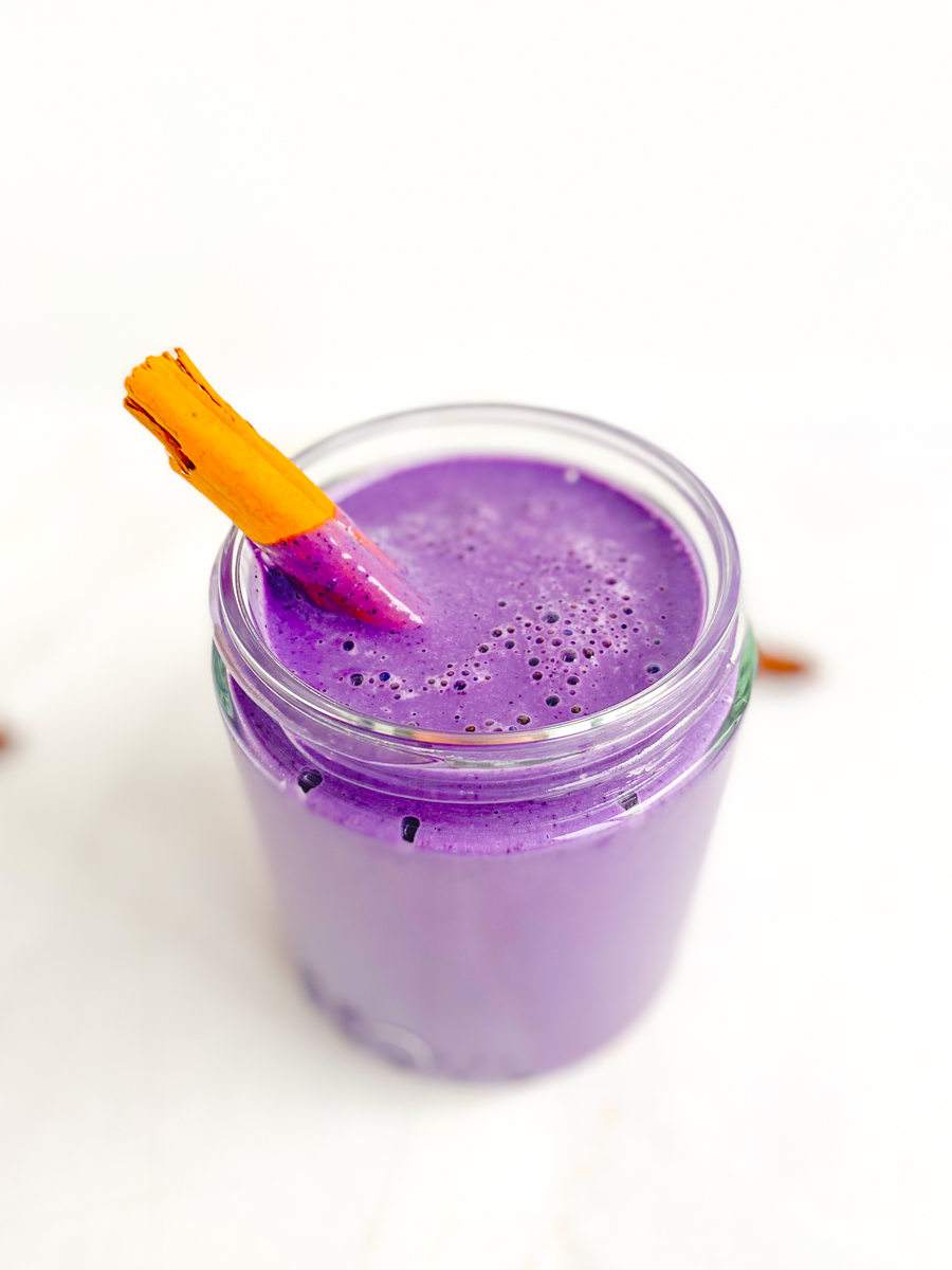 Blueberry smoothie in a wide-mouth jar with cinnamon stick
