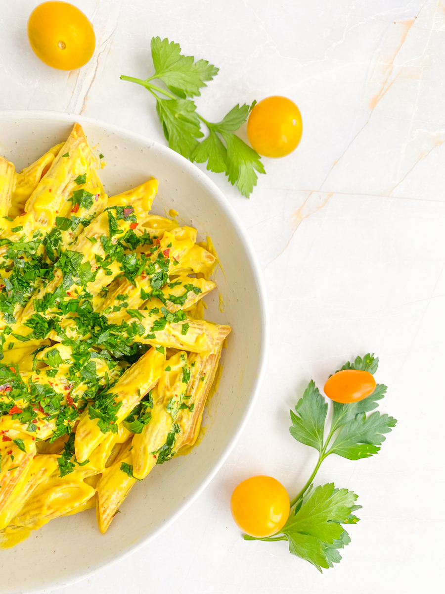 Vegan Mac and Cheese in a bowl sprinkled with spring onions and red pepper flakes